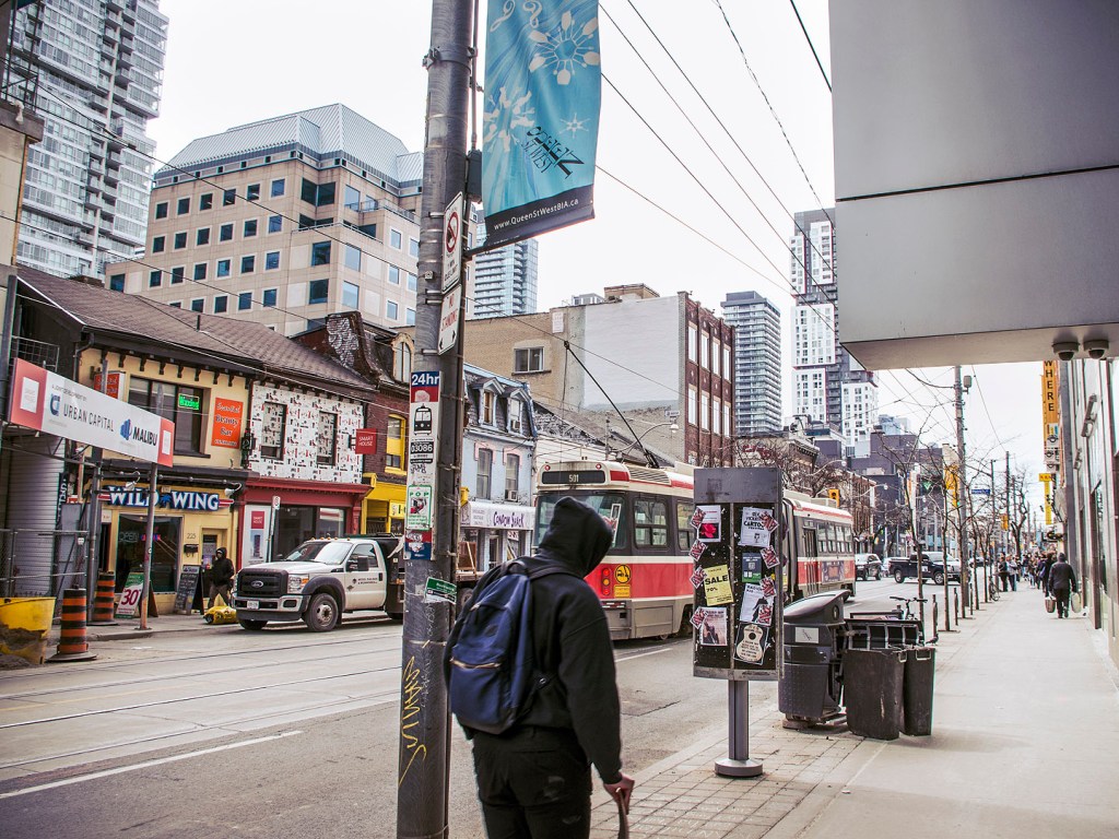 Tram and pedestrian on a street in Toronto