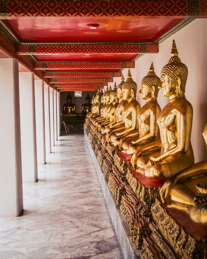 A line of golden Buddha statues at the Wat Pho temple complex in Bangkok