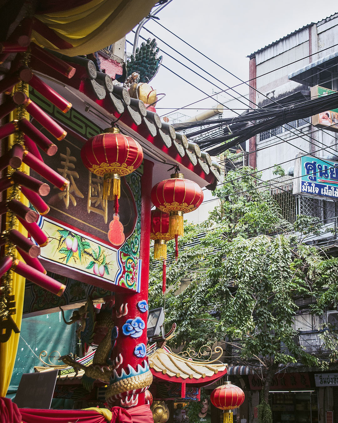 Red and yellow lanterns and colourful art in Bangkok's Chinatown.