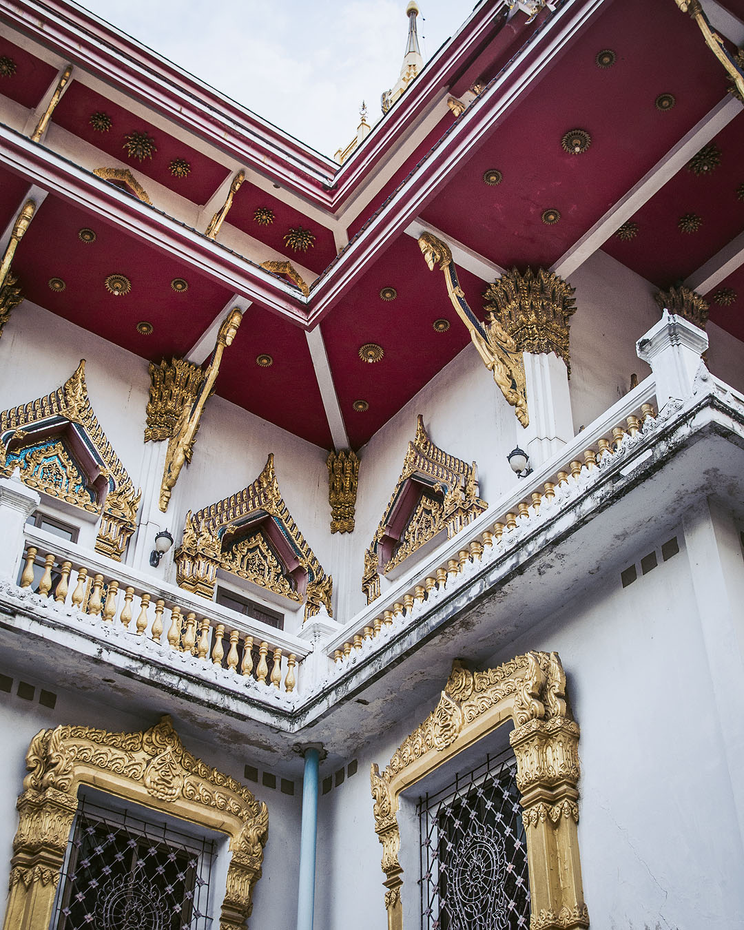 Looking up at the golden windows and red roof of Wat Samphanthawong (Wat Ko).