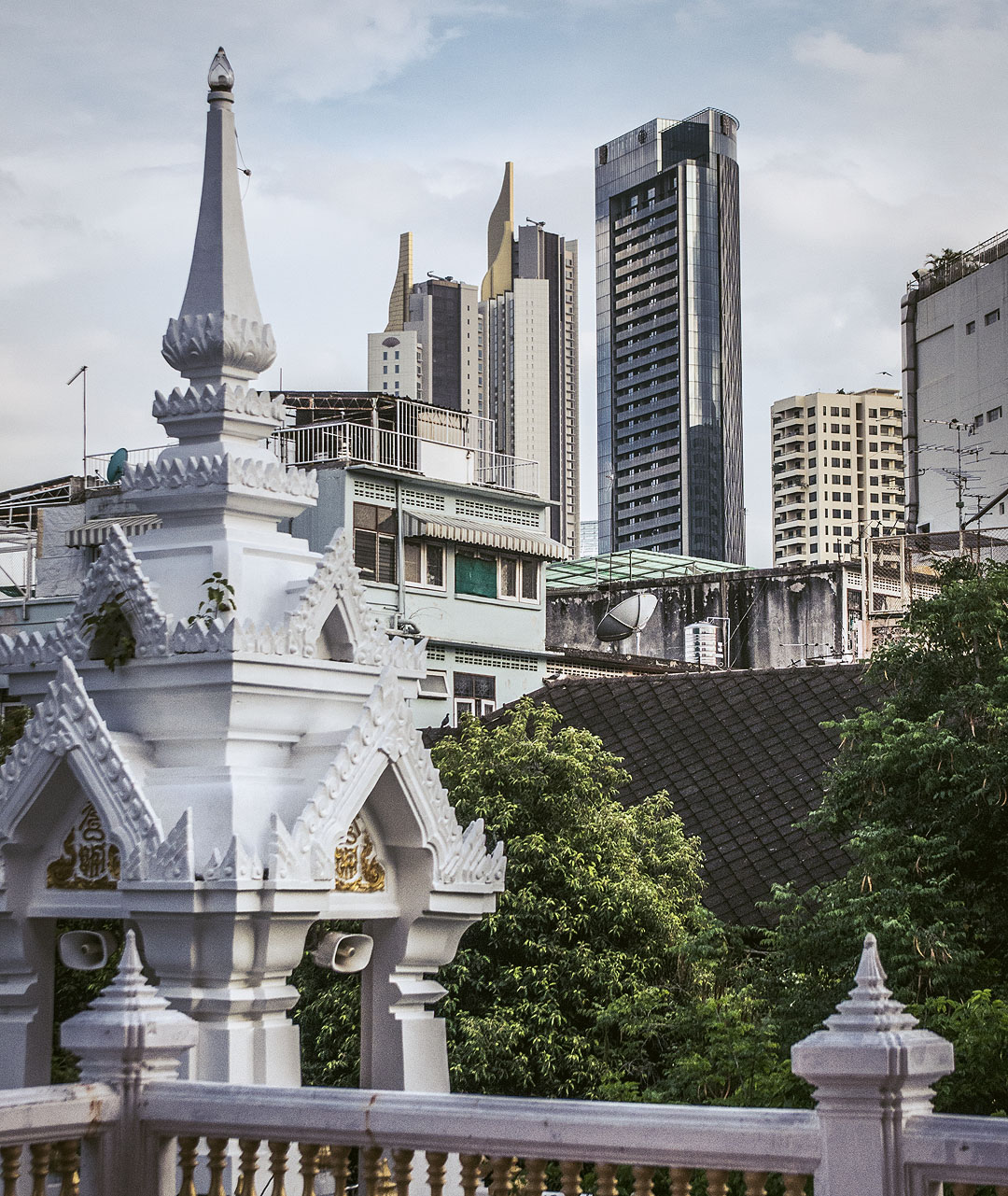 The belfry of Wat Samphanthawong (Wat Ko) with skyscrapers in the background.