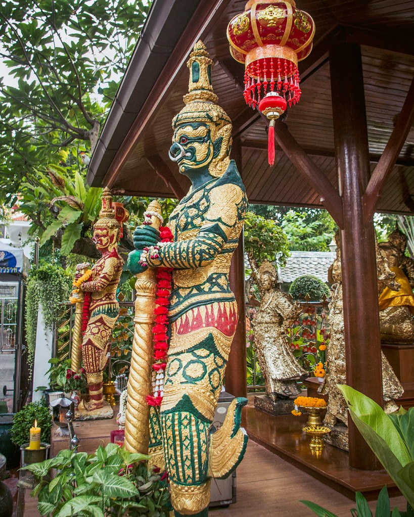 A green and gold demon guardian at Wat Samphanthawong.