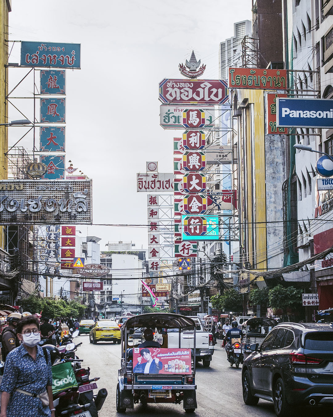 Store signs, cars a tuktuk on Yaoworat Road in Bangkok's Chinatown.