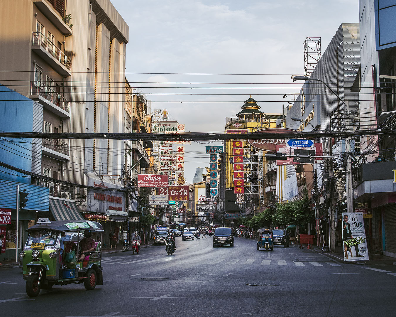 Store signs, motorbikes and cars on Yaoworat Road in Bangkok's Chinatown.
