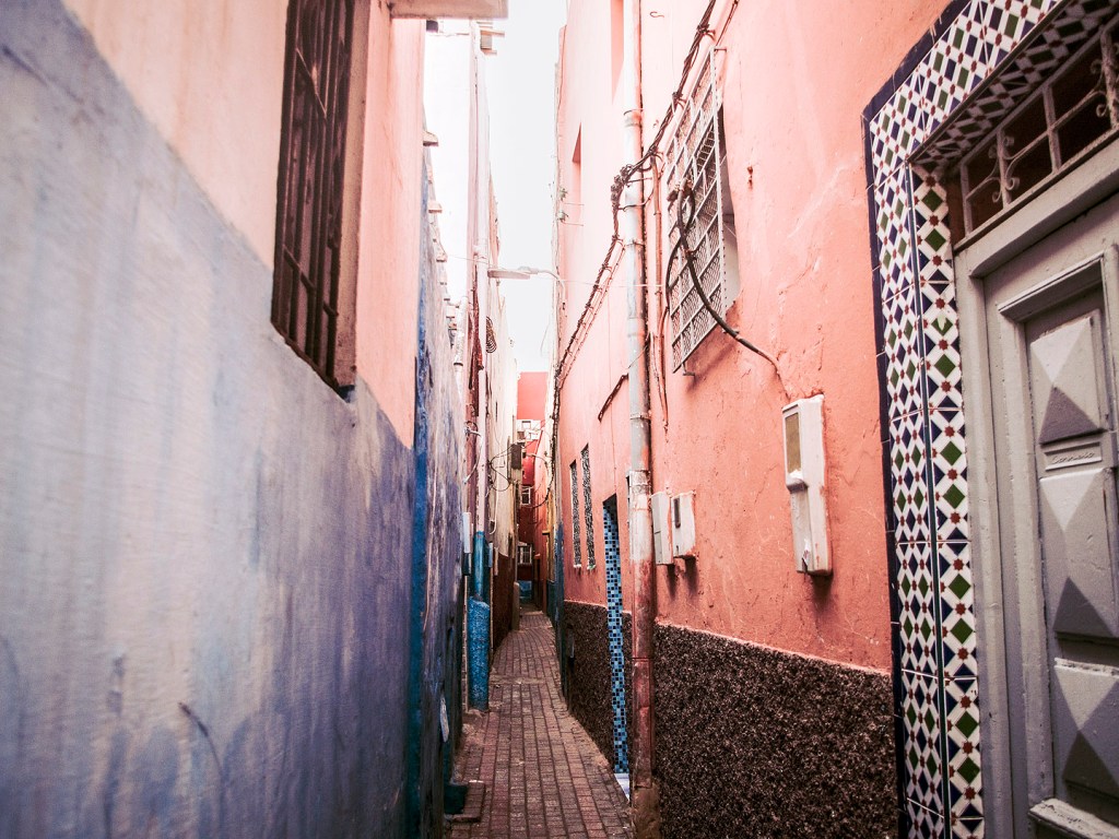 Pink and blue buildings in an alleyway in Salé, Morocco.
