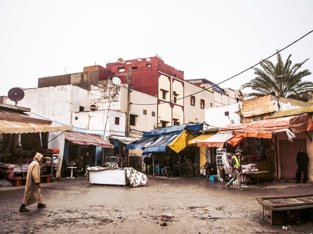 A man crossing a plaza in the souk in Salé, Morocco.