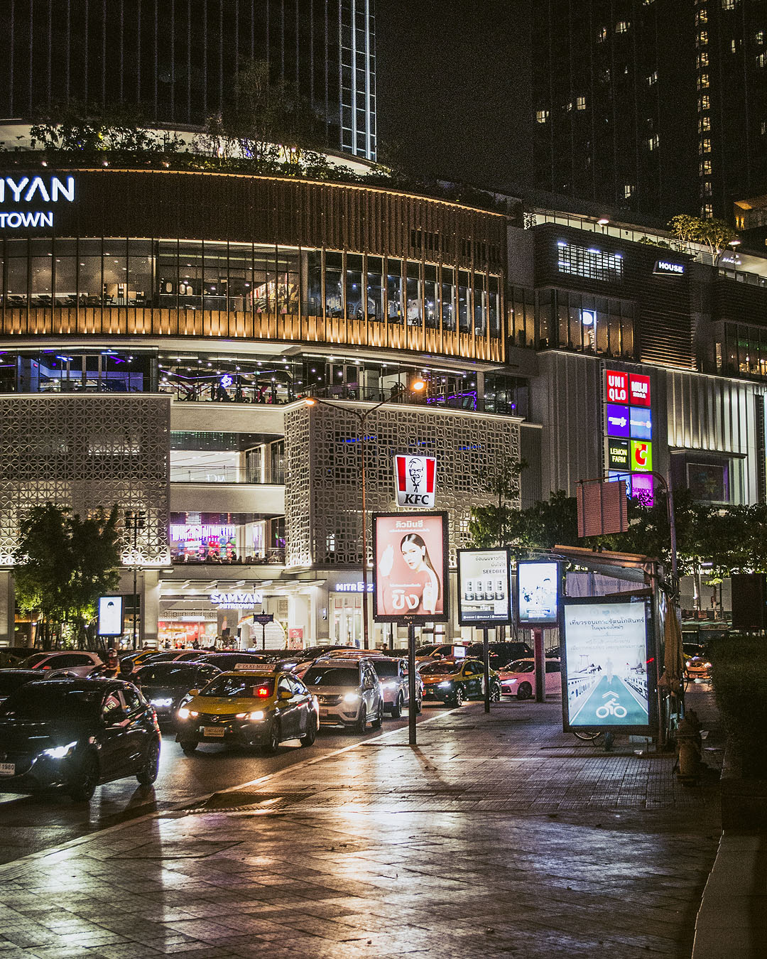 Cars in front of the Samyan Mitrtown shopping mall at night.