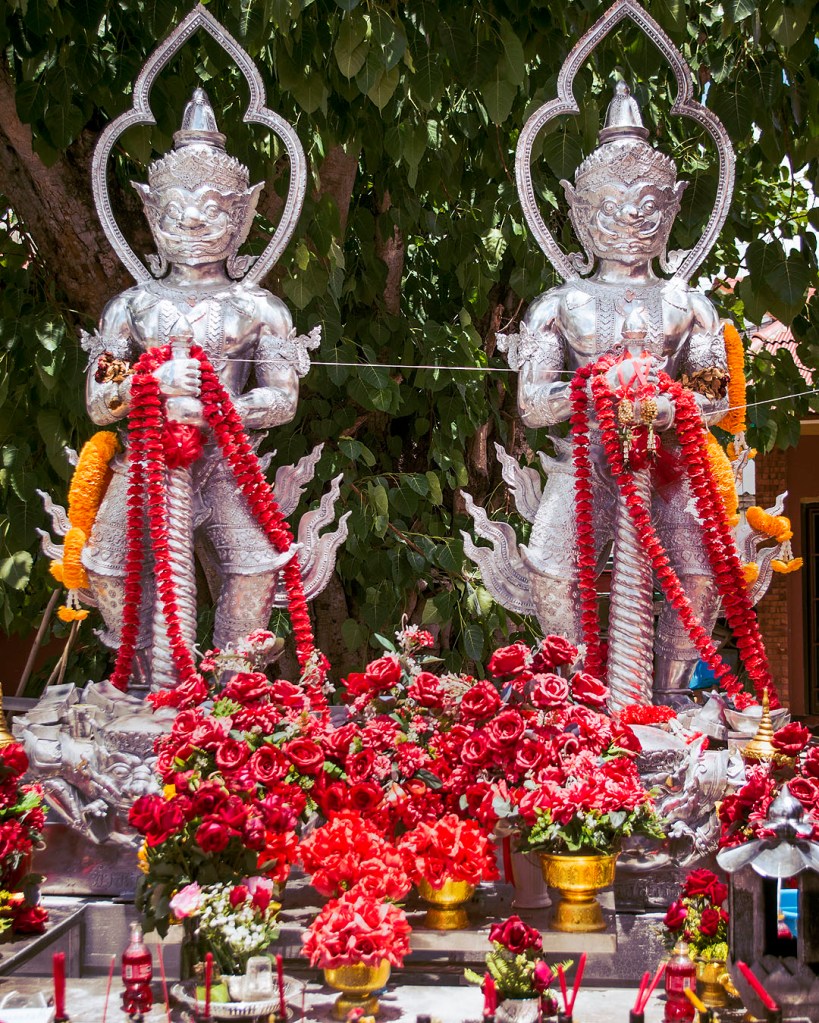 Silver demons and floral offerings at Wat Sri Suphan in Chiang Mai.