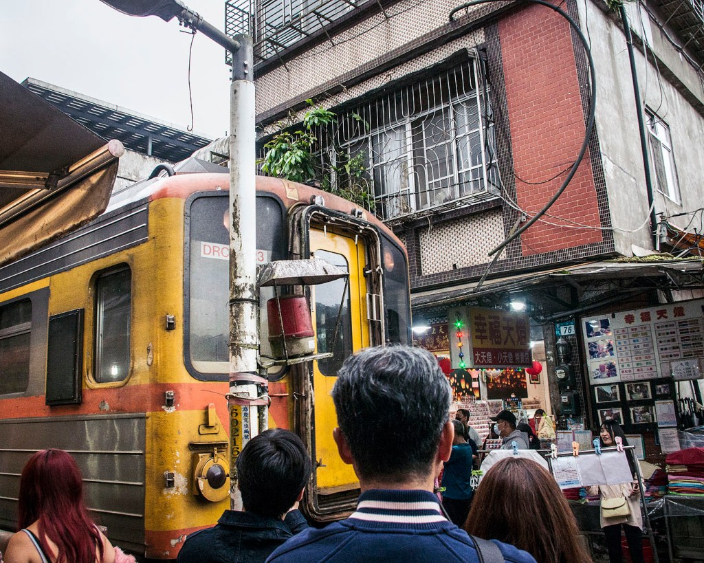 A train passing through the narrow Shifen Old Street.